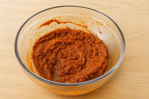 Homemade taco seasoning paste with cumin, paprika, garlic powder, and lemon juice mixed in a bowl for chicken tacos