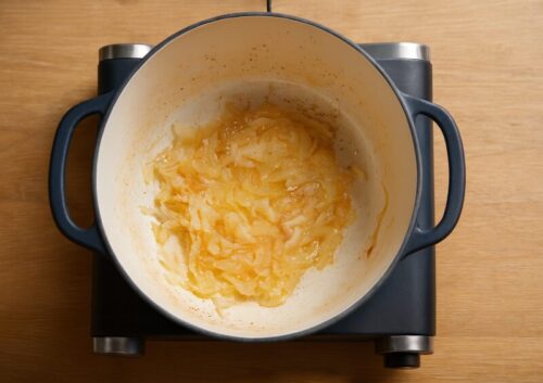 Chickpea-and-Spinach-curry-recipe-1 Sautéing chopped onions, ginger, and garlic in oil in a deep pan for curry base preparation.