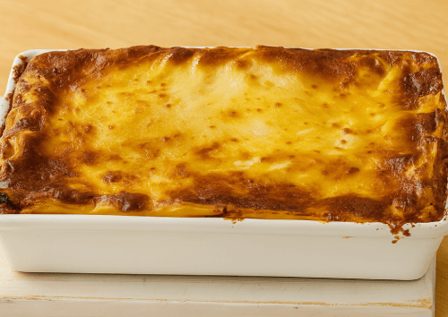 Classic-Beef-Lasagna-3 Layering lasagna sheets, bolognese sauce, and bechamel in baking dish after oven bake