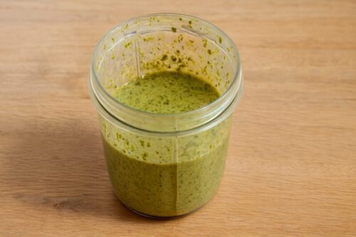 Garlic-Herb-Roasted-Chicken-1 Fresh garlic, herbs, lemon zest, and olive oil blended into a thick green marinade with visible herb flecks for garlic herb roasted chicken.