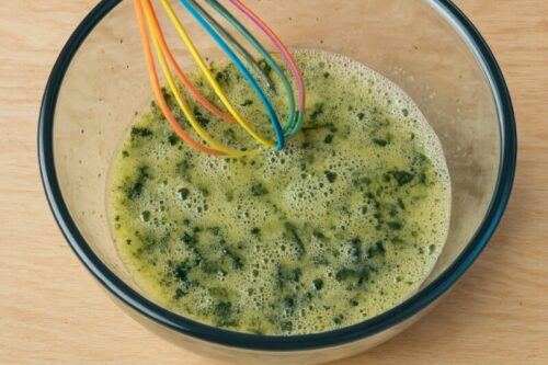 Quesadilla-1 Beaten eggs in a mixing bowl with chopped spinach, salt, pepper, and garlic powder, ready for breakfast quesadilla filling.