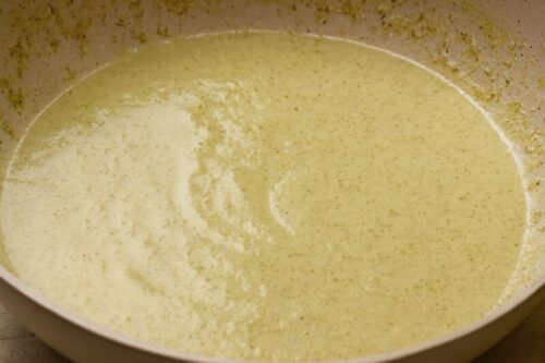 Green curry paste stirred into aromatics, followed by pouring 200ml coconut milk for creamy base